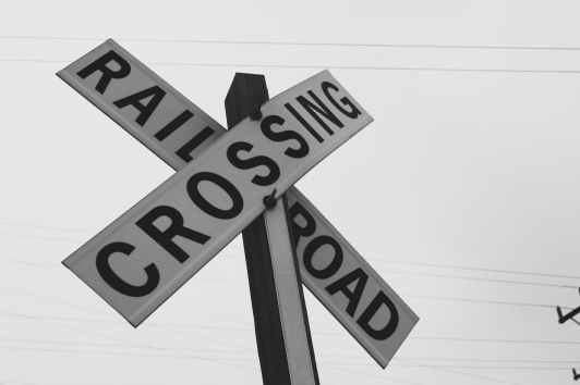 grayscale photography of railroad crossing signage
